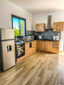 a kitchen with wooden floors and a refrigerator at Villa cap zen and spa in Petite Île