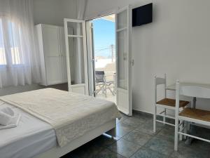 sypialnia z łóżkiem i stołem oraz balkonem w obiekcie Vavanos Studios w mieście Nausa