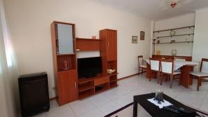 uma sala de estar com televisão e uma sala de jantar em Palmeiras em Arcozelo