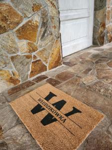 a welcome mat in front of a door at Włudzikówka in Polana