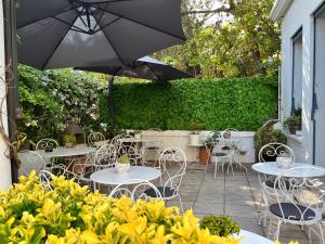 a patio with tables and chairs and an umbrella at Hotel Albert 1er in Cannes