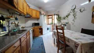 uma cozinha com uma mesa e um frigorífico branco em Palmeiras em Arcozelo