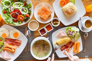 a table topped with plates of food and bowls of soup at Kacha Resort & Spa, Koh Chang in Ko Chang