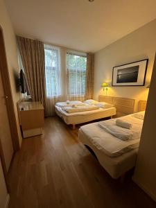 una camera d'albergo con due letti e una televisione di Mitt hotell & apartments a Moss
