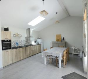 a kitchen with a white table and a table and chairs at LA CAMPAGNE in Nérac