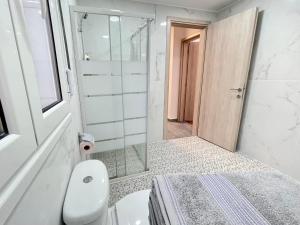 y baño con ducha, aseo y lavamanos. en 4-bedroom Family apartment in the center of Athens, en Atenas