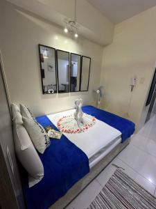 a bedroom with a bed with a blue and white blanket at Green Residences Stays by PBYY in Manila