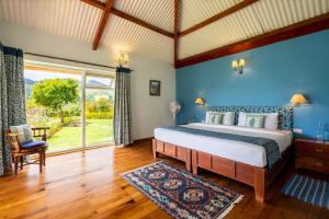 une chambre avec un lit et une grande fenêtre dans l'établissement amã Stays & Trails Raven's Nest , Kotagiri, à Kotagiri