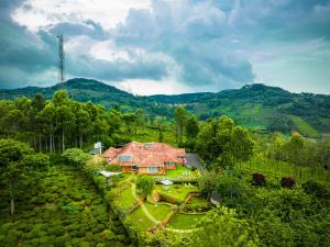 une vue aérienne d'une maison sur une colline dans l'établissement amã Stays & Trails Raven's Nest , Kotagiri, à Kotagiri