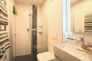 a bathroom with a shower and a toilet and a sink at Frühstückspension Jagdhof in Obertilliach