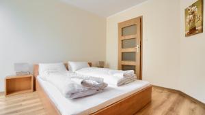 una camera con letto e lenzuola bianche di Apartamenty Sun & Snow Morskie Oko a Międzyzdroje