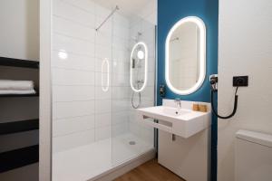y baño con lavabo y ducha con espejo. en ibis Perpignan Sud Saint Charles, en Perpiñán