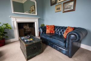 a blue living room with a black leather couch at Crescent Green in Bath +16 photos