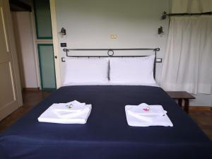 Una cama con dos toallas blancas encima. en Le Case Gialle, en Gualdo Cattaneo