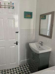 a white bathroom with a sink and a mirror at Flat Beside the sea in Southend-on-Sea