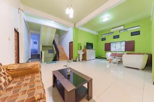 uma sala de estar com um sofá e uma mesa em Urbanview Hotel 99 Syariah Banjarbaru by RedDoorz em Martapura