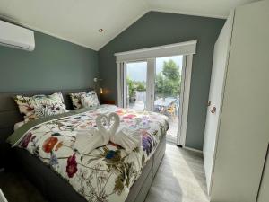 Un dormitorio con una cama con dos cisnes. en New - Waterfont Villa08 - Private Residence on a lake near Amsterdam en Vinkeveen