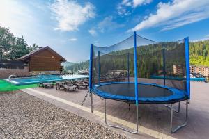 acovered patio with a trampoline and a pool at Gold Palace Bukovel in Bukovel