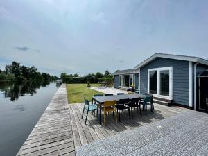una casa en un muelle con mesa y sillas en New - Waterfont Villa08 - Private Residence on a lake near Amsterdam en Vinkeveen