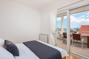 1 Schlafzimmer mit einem Bett und einem Balkon mit einem Tisch in der Unterkunft Apartment Tihi in Vodice