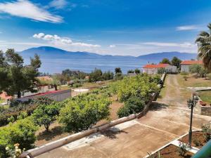a view of a garden with mountains in the background at Coastal SeaCharm - Theotokos Sandyfill Getaway in Nerotriviá