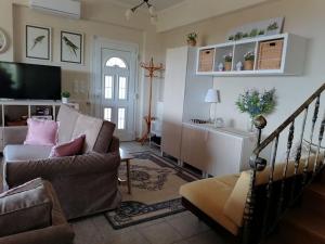 a living room with a couch and a tv at Coastal SeaCharm - Theotokos Sandyfill Getaway in Nerotriviá