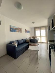 sala de estar con sofá azul y mesa en Apartment-Duplex, El Medano, en El Médano