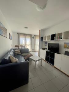 sala de estar con sofá, TV y mesa en Apartment-Duplex, El Medano, en El Médano