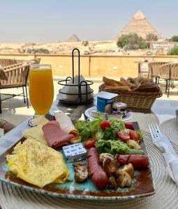 a plate of food on a table with a glass of beer at The Gate Hotel Pyramids in Cairo