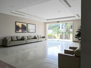 a large living room with couches and a large window at Aria Resort- Căn hộ nghỉ dưỡng tầng 8 hướng biển, hồ bơi sát cạnh bãi tắm riêng (miễn phí) in Xa Thang Nhut