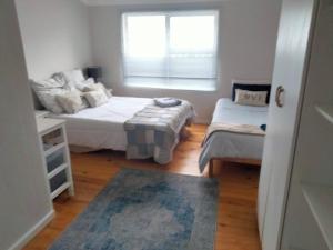 a small bedroom with two beds and a window at Pêrel of Perlemoenbaai in Gansbaai