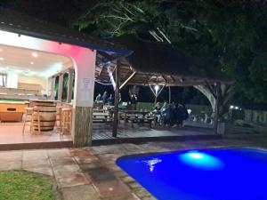 a swimming pool in front of a restaurant at night at Eden Wilds 6 Paradise on Umtavuna River in Port Edward