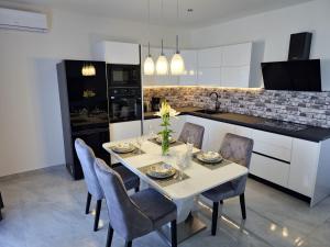 een keuken met een witte tafel met stoelen en een aanrecht bij J&D luxury apartment in Podstrana