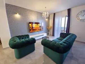 een woonkamer met twee groene banken en een klok bij J&D luxury apartment in Podstrana