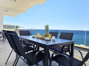 een blauwe tafel en stoelen op een balkon met uitzicht op de oceaan bij J&D luxury apartment in Podstrana