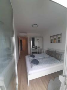 a bedroom with a white bed and a mirror at Silver Side Apartments in Siófok