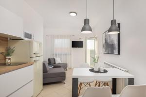 a kitchen and living room with a table and chairs at Apartments Tihi in Vodice