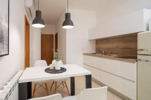 eine Küche und ein Esszimmer mit einem weißen Tisch und Stühlen in der Unterkunft Apartment Tihi in Vodice