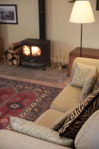 a living room with a couch and a fireplace at Eastside Steading - Family barn in the Pentland Hills, Edinburgh in Penicuik