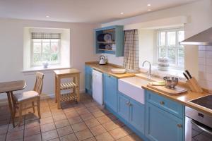 a kitchen with blue cabinets and a counter top at Eastside Steading - Family barn in the Pentland Hills, Edinburgh in Penicuik