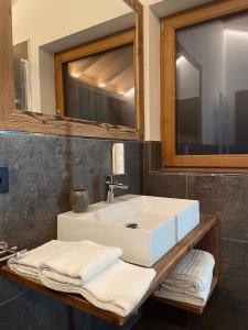 a bathroom with a sink and a mirror and towels at B&B Al Mulin in Padola