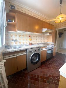 a kitchen with a washing machine and a sink at Apartamento Centro Gijón Los Patos in Gijón +8 photos