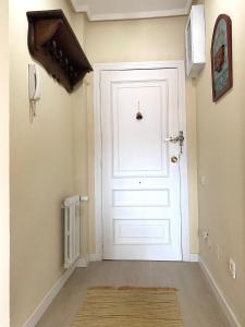 a white door in a hallway with a rug at Apartamento Centro Gijón Los Patos in Gijón