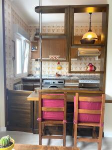 a kitchen with a wooden table and two chairs at Apartamento Centro Gijón Los Patos in Gijón