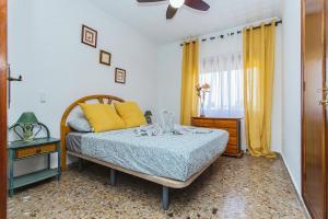 a bedroom with a bed with yellow pillows and a window at 250 Finca CODOVI - Alicante Holiday in Los Montesinos +37 photos