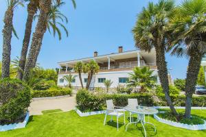 a house with palm trees and a table in the yard at 250 Finca CODOVI - Alicante Holiday in Los Montesinos