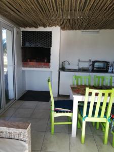 une cuisine avec une table, deux chaises et un comptoir dans l'établissement The Tides Holiday Home, à St Helena Bay