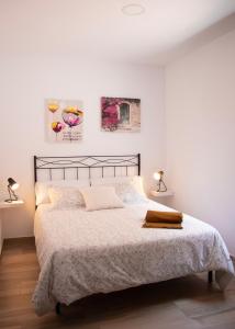 奧薩德蒙鐵爾的住宿－Casas rurales La Carrasca，白色卧室配有一张带两盏灯的大床