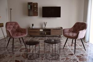 a living room with two chairs and a tv at Russo Apartment in Termoli