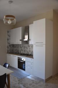 una cucina con armadietti bianchi e frigorifero bianco di Russo Apartment a Termoli